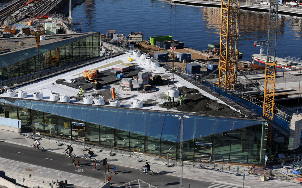 Byggmaterial och sandhögar på ett tak.